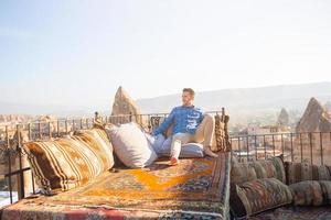 Happy young man on the roof in Cappadocia, Turkey photo