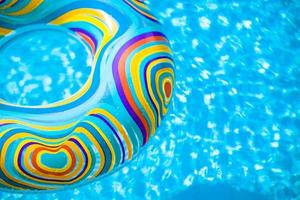 Inflatable colorful Rubber Ring floating in blue swimming pool photo