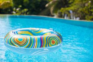 flotador de piscina colorido en cuenca de natación azul foto
