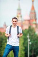 Young man hiking smiling happy portrait. Male hiker walking in the city photo