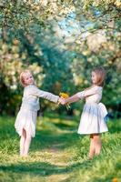 bellas chicas en el floreciente jardín de manzanos disfrutan de un cálido día de primavera foto