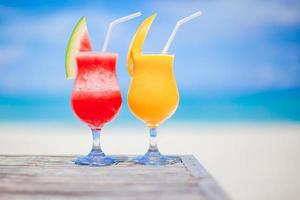 Two cocktails of watermelon and mango on background of stunning turquoise sea photo