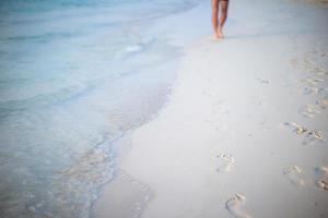 Human footprints on white sand beach photo