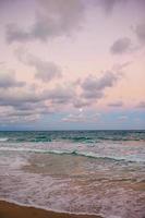 Beautiful full moon over the sea at colorful sunset on the beach photo