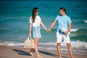 Young couple in love on the beach summer vacation. Happy man and woman look at the sea photo