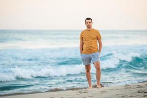 joven caminando por la playa al atardecer foto