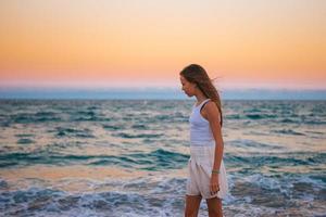 linda adolescente hermosa chica en la costa tropical al atardecer foto