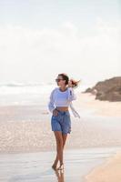 Young happy woman on the beach enjoy her summer vacation. Girl is happy and calm in her stay on the beach photo