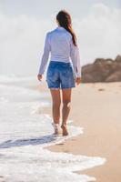 joven feliz caminando por la playa foto