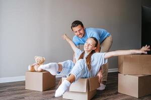 Family of father and adorable teen daughter have fun on moving day in their new home photo