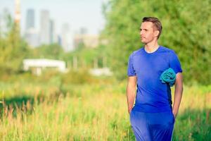 Sportive young man doing sport exercises outdoors in the park photo