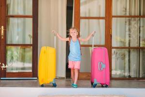 Adorable little girl with luggages ready for traveling photo