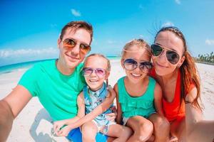 Happy beautiful family on white beach having fun photo