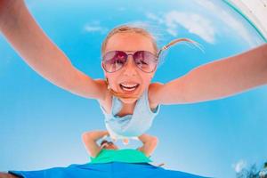 Active little girl on white beach having fun. Closeup kid background the sea photo