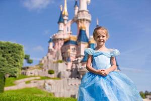 Little adorable girl in beautiful princess dress at fairy-tale park photo