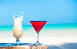 Two cocktails pina colada and strawberry margarita on wooden table photo