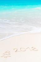 2018 handwritten on sandy beach with soft ocean wave on background photo