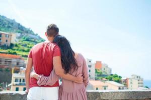 Young family with great view at old village Riomaggiore, Cinque Terre, Liguria, Italy. European italian vacation. photo