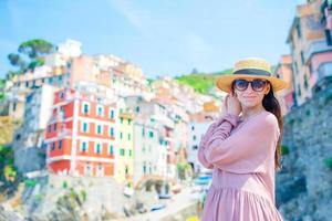 Young woman with great view at old village Riomaggiore, Cinque Terre, Liguria, Italy. European italian vacation. photo