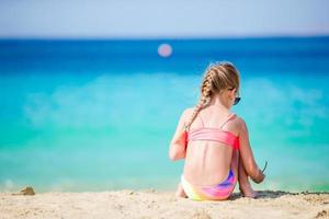 adorable niña activa en la playa durante las vacaciones de verano foto