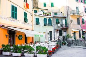 Old beautiful empty narrow streets with outdoor cafe in coastal village in Cinque Terre, Italy photo