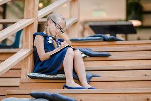 Adorable little school girl with notes and pencils outdoor. Back to school. photo