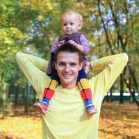 Young father walking with her little cute daughter in the autumn park outdoors photo