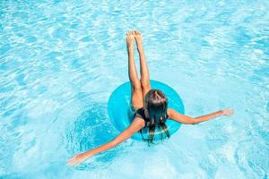 Little adorable girl in outdoor swimming pool photo