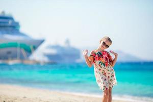 Adorable little girl at beach background big cruise lainer in Greece photo