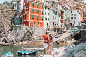 Tourists looking at scenic view of Riomaggiore, Cinque Terre, Liguria, Italy photo