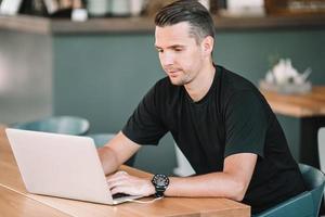 Young man with laptop works from home photo