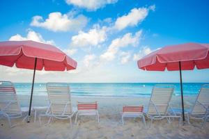 Paradise view of tropical empty sandy plage with umbrella and beach chair photo
