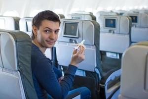 Happy man with small model airplane inside a large aircraft photo