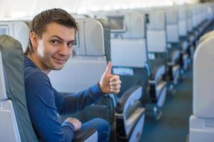 Happy man showing thumbs up inside the aircraft photo