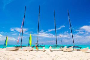 grupo de catamaranes con velas coloridas en la exótica playa caribeña foto