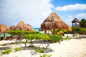 Paradise view of nice tropical empty sandy plage with umbrella and beach chair photo