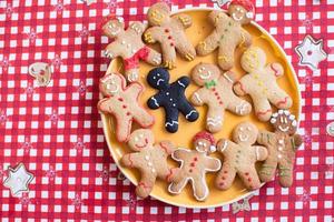 Sad burnt gingerbread man among finished with colored glaze photo