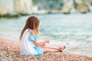 Little adorable girl playing on beach with ball photo