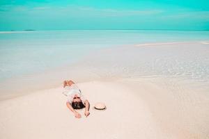 Woman laying on the beach enjoying summer holidays looking at the sea photo