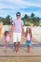 familia de tres en un embarcadero de madera junto al océano foto