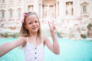 Adorable little girl background Trevi Fountain, Rome, Italy. photo