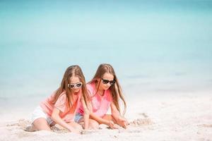 las niñas divertidas y felices se divierten mucho en la playa tropical jugando juntas. foto