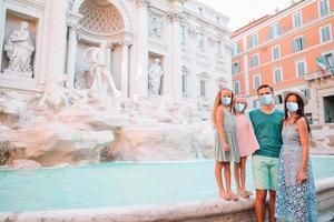 Happy family near Fontana di Trevi in masks photo