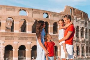 Happy family in Europe. Parents and kids in Rome over Coliseum background photo