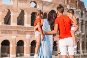Happy family in Europe. Parents and kids in Rome over Coliseum background photo