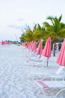 Paradise view of tropical empty sandy plage with umbrella and beach chair photo