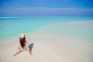 mujer joven disfruta de vacaciones en la playa tropical en maldivas foto
