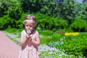 Little girl blowing a dandelion outdoor photo