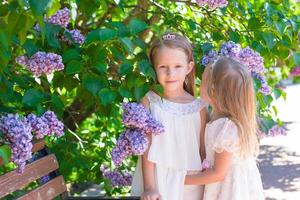 Little adorable girls in lush park in summer vacation photo