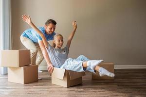 Happy father with daughter have fun in their new home. Family enjoy their moving day photo